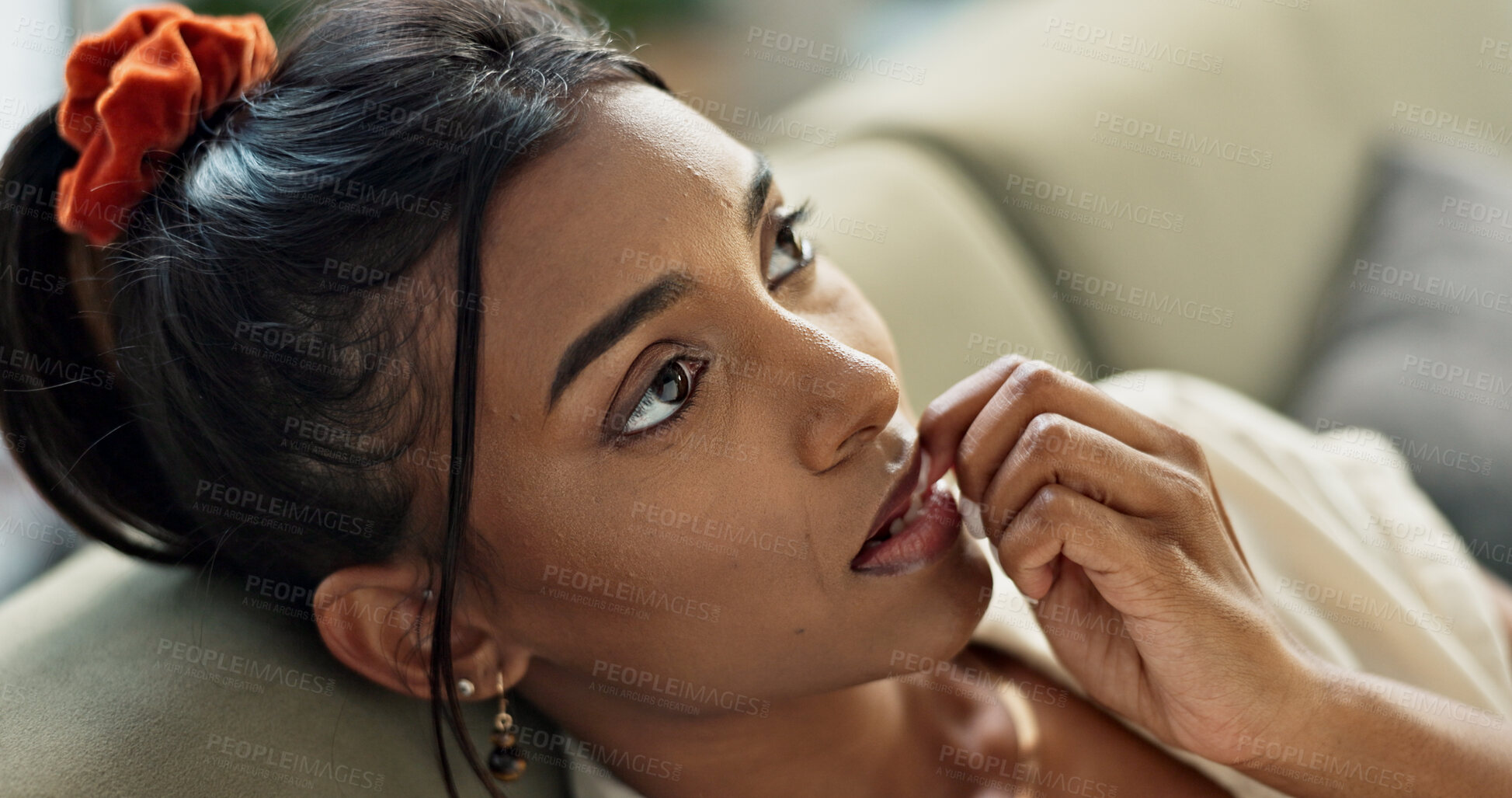 Buy stock photo Thinking, anxiety and young woman on a sofa relaxing with an idea or memory in living room. Anxious, mental health and nervous Indian female person biting her nail in the lounge of modern apartment.