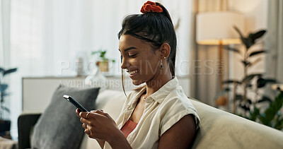 Woman, typing and smile in home with smartphone, social network or update multimedia subscription on sofa. Happy indian girl relax with cellphone app, download mobile games or chat to digital contact
