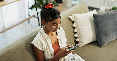 Woman, typing and scroll on smartphone in home for social network, update multimedia subscription or chat on sofa from above. Indian girl, phone and download mobile games, reading notification or app