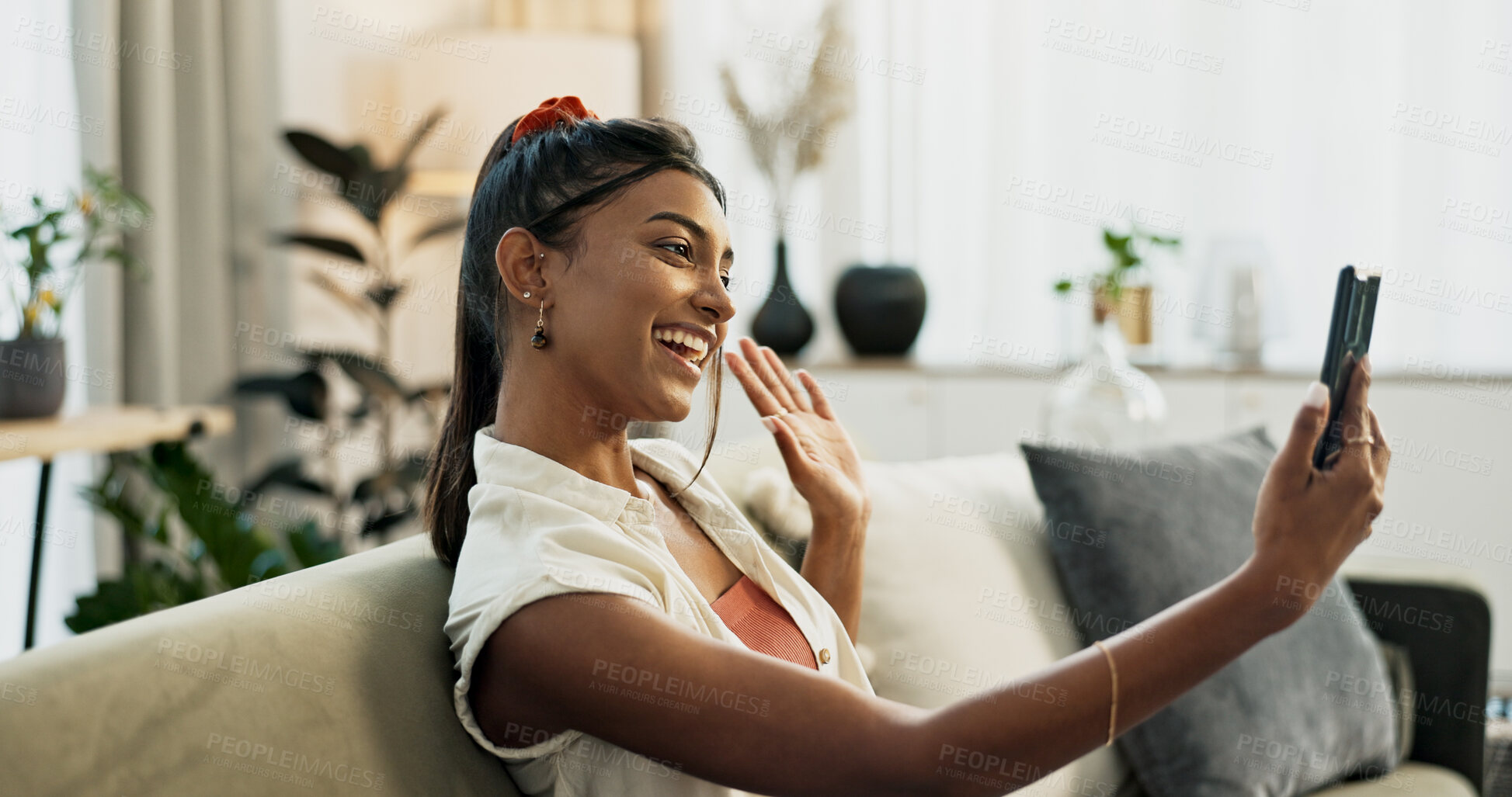 Buy stock photo Phone, happy or Indian woman on a video call on a sofa or couch to relax in living room or apartment. Wave, communication or excited person on mobile conversation with smile in lounge of modern home