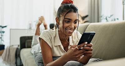 Buy stock photo Phone, happy and woman on sofa typing in home, social media and reading email notification to relax. Smartphone, smile and Indian person in living room on mobile app, scroll website and communication