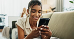 Phone, smile and woman on sofa typing in home, social media and reading email notification to relax. Smartphone, happy and Indian person in living room on mobile app, scroll website and communication