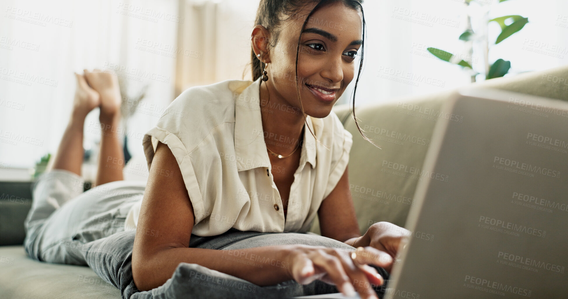 Buy stock photo Happy woman, remote work and typing on sofa with laptop to update blog post, social media or digital subscription. Indian freelancer relax with computer for online shopping, elearning and check email