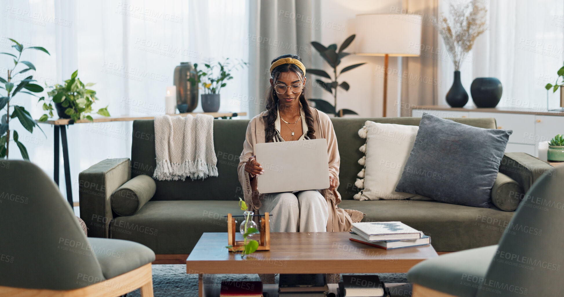 Buy stock photo Freelance, laptop and Indian woman on sofa for social media, research or streaming at home. Tech, remote work or lady entrepreneur online in living room for email, learning or upskill training course