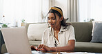 Home, woman typing on laptop and remote work, internet search or blog in living room. Computer, smile and Indian freelancer in lounge on table, online website or reading email on digital technology