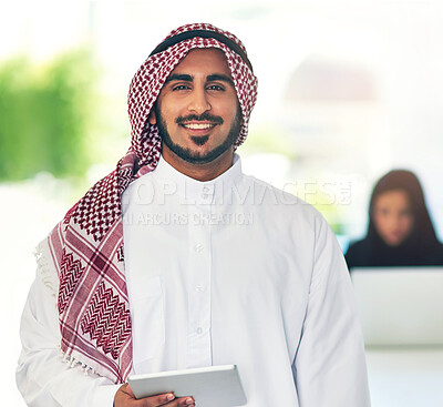 Buy stock photo Portrait of a young muslim businessman holding a digital tablet with her colleague working in the background