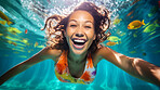 Portrait of smiling young woman underwater in swimming pool. Vacation, holiday concept.
