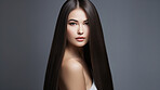 Portrait of young woman with long straight black hair. Hair care, make-up and hair health