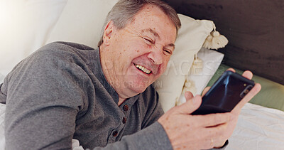 Buy stock photo Happy, senior man and reading with phone in bed or streaming funny, comedy or meme on social media. Elderly person, smile or relax with cellphone at night in bedroom with communication or online chat