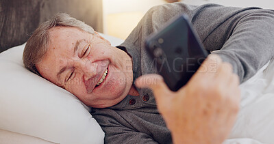 Senior man, happy and reading with phone in bed or streaming funny, comedy or meme on social media. Elderly person, smile or relax with cellphone at night in bedroom with communication or online chat