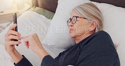 Buy stock photo Phone, relax and elderly woman in bed networking on social media, mobile app or internet. Technology, rest and senior female person in retirement scroll on website with cellphone in bedroom at home.