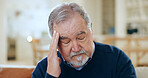Senior man, headache and stress in mistake, financial crisis or retirement debt on living room sofa at home. Mature male person with migraine, anxiety or depression in loss or mental health at house