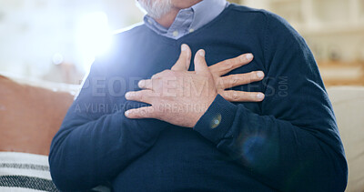 Hands, chest and heart attack with a senior man closeup on a sofa in the living room of his home during retirement. Healthcare, medical and cardiac arrest with an elderly person in pain or agony