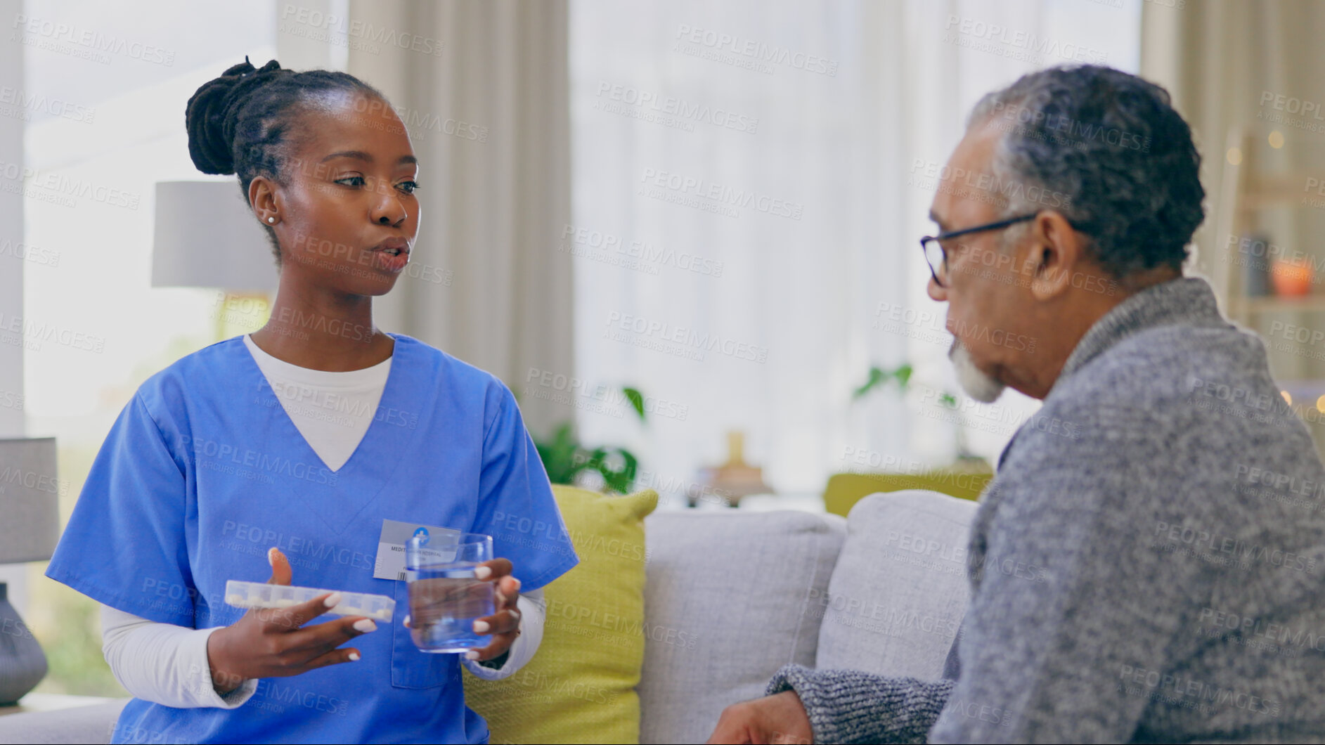 Buy stock photo Assisted living, healthcare of medicine with an old man and nurse in a home for medical care or treatment. Help, pills or chronic medication with a black woman volunteer talking to a senior patient