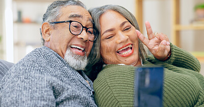 Senior couple, selfie and peace sign on sofa with smile, hug and bonding with love in home living room. Elderly woman, old man and photography for memory with emoji, icon and post on social network