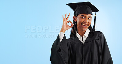 Buy stock photo Woman, graduation and space with ok sign, studio and review for vote, choice or support by blue background. Student girl, thinking and celebration for icon, emoji and decision for mockup with goals