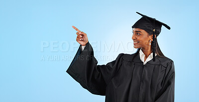 Graduation student, studio and happy woman point at learning news, university info or college development. Mockup space, promotion and graduate gesture at education opportunity on blue background