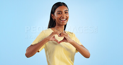 Buy stock photo Heart, hands and woman in portrait with support, charity and love sign with smile on blue background. Health, wellness and donation with care, icon or symbol, emoji and happy with kindness in studio