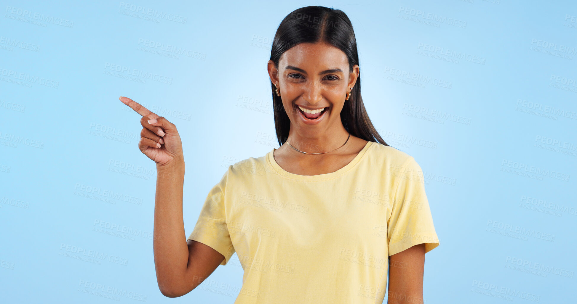 Buy stock photo Woman, pointing and portrait with marketing, advertising and direction for announcement in studio. Blue background, person and promotion with smile and sale with offer and show hand sign of student