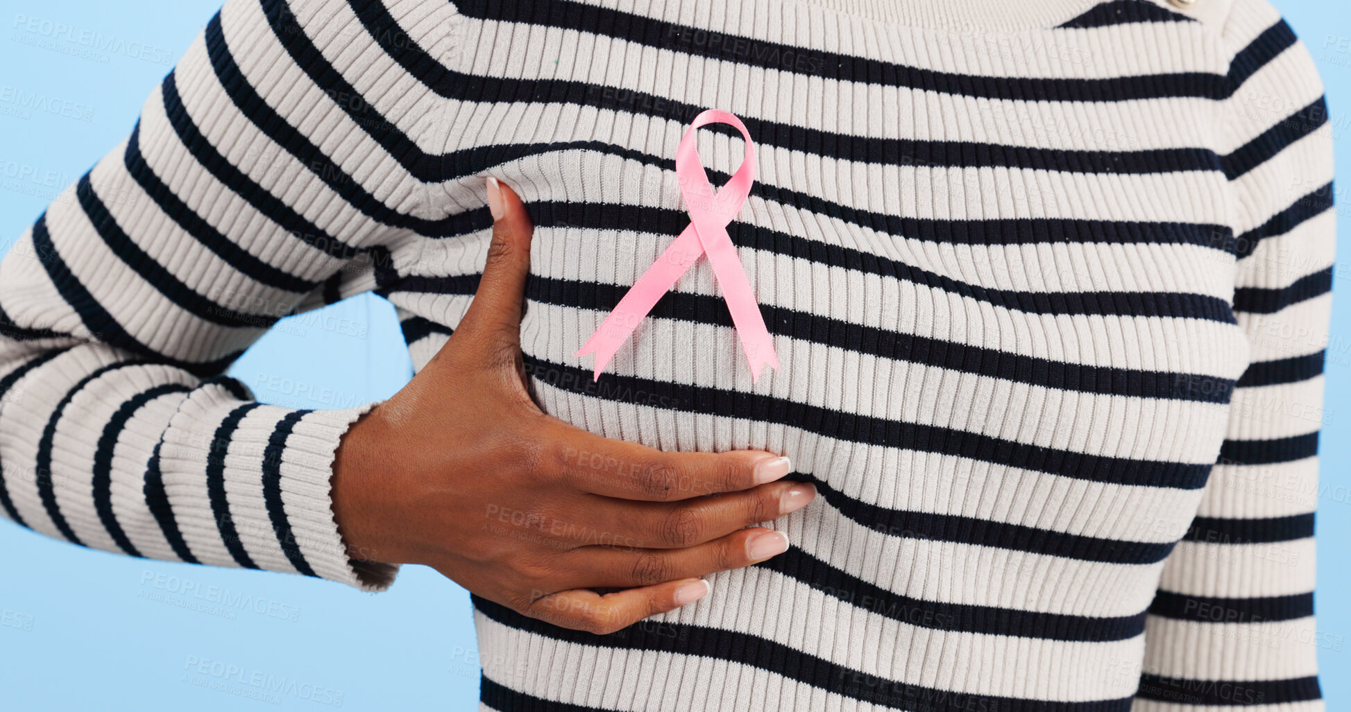 Buy stock photo Hand, show pink ribbon and breast cancer support with awareness and health icon on blue background. Person in studio, medical symbol and wellness with care, trust and kindness in solidarity campaign