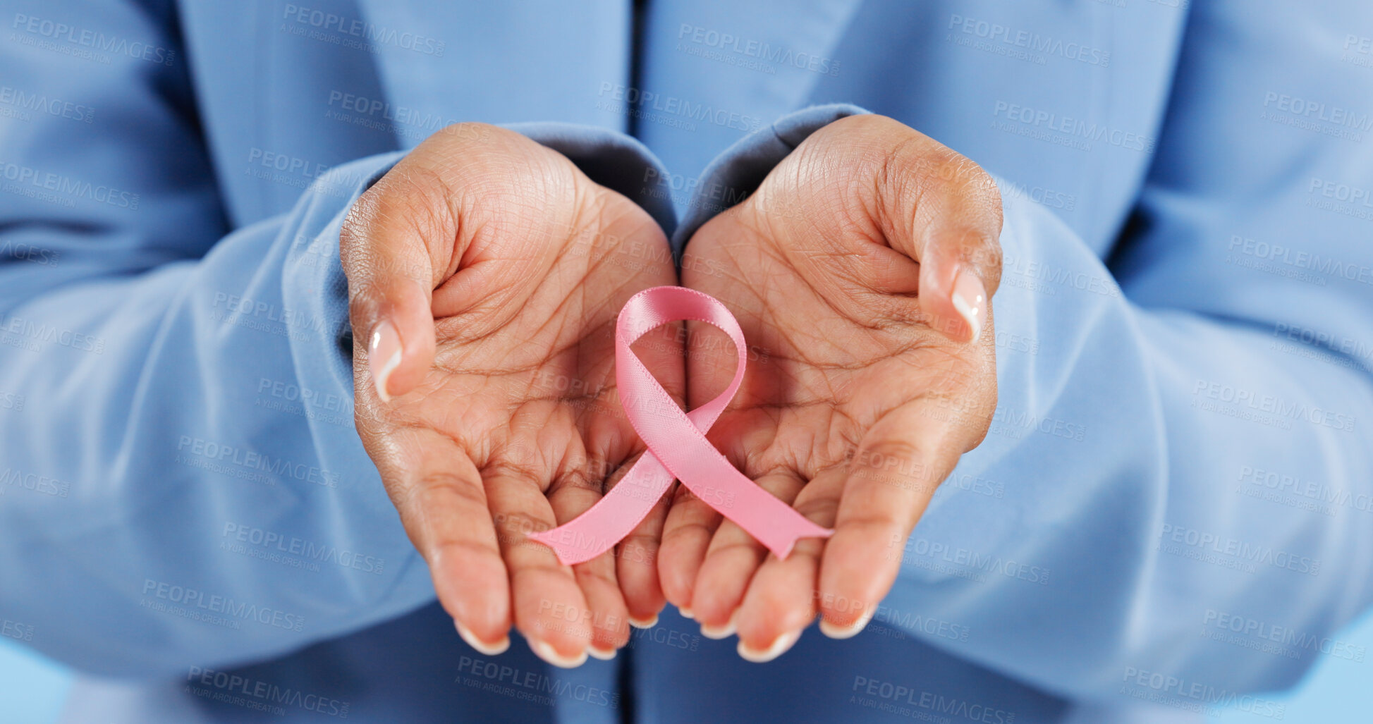 Buy stock photo Hands, pink ribbon and breast cancer support with awareness and healthcare icon on blue background. Person in studio, medical symbol and wellness with care, trust and kindness in solidarity campaign