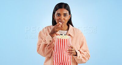 Buy stock photo Portrait, watching tv and woman with popcorn, excited and happiness on a blue studio background. African person, girl or model with cinema snack, eating a treat or streaming a movie with mockup space