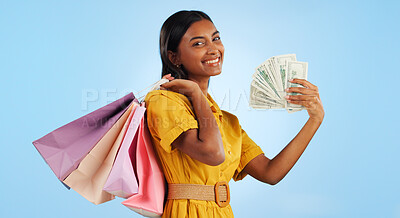 Woman, shopping bag and cash fan, wealth and commerce with customer in portrait on blue background. Money, financial freedom and retail, fashion and product choice, rich and store discount in studio