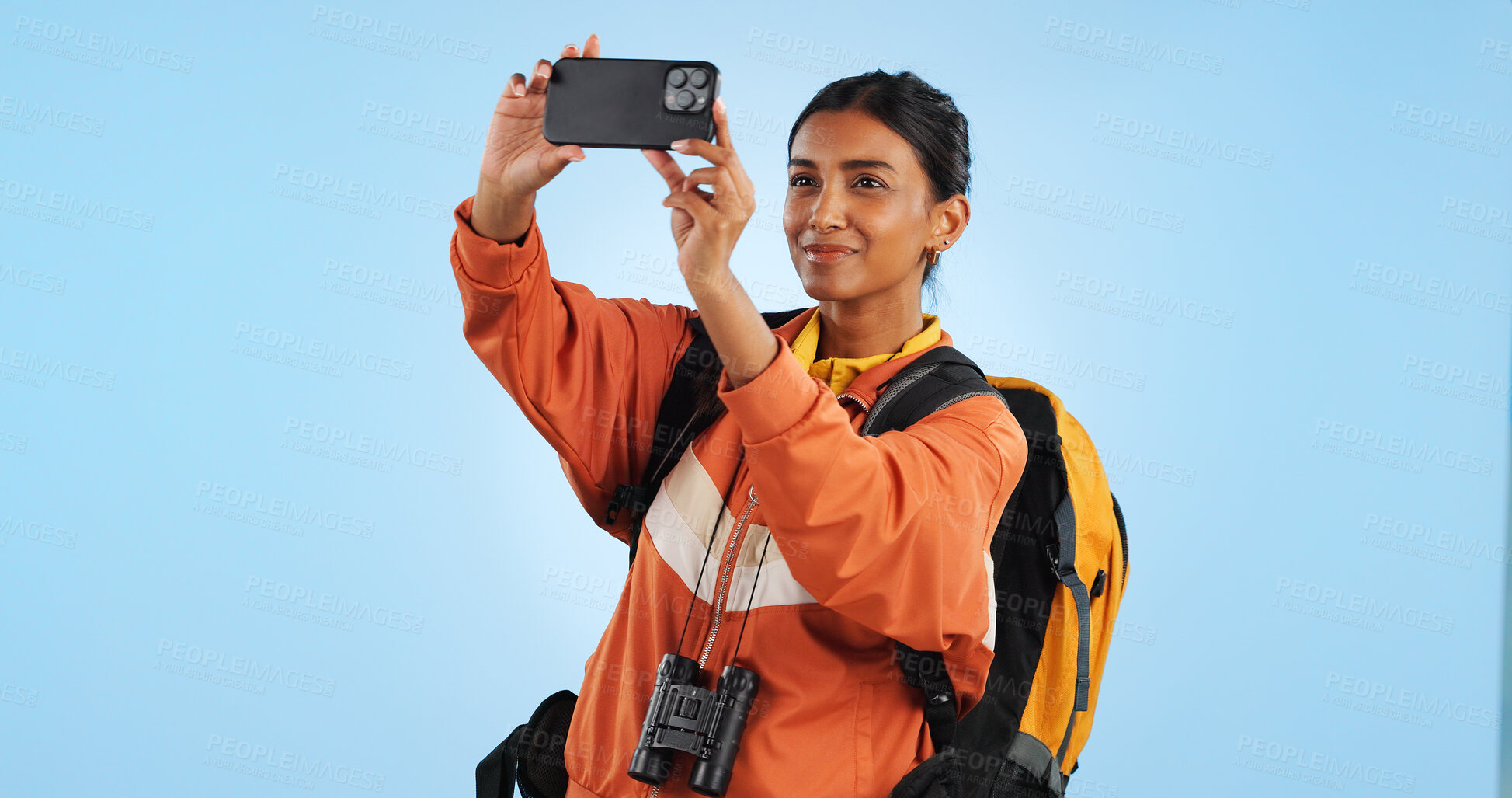 Buy stock photo Hiking studio, phone picture and woman trekking, sightseeing and shooting holiday photo. Cellphone, camper and nature photography for social media memory, online post or adventure on blue background