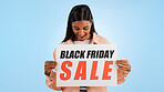 Woman, promotion poster and black friday with sale, discount and billboard in studio. Excited, smile and happy from savings and deal with banner and promo with blue background and price decrease