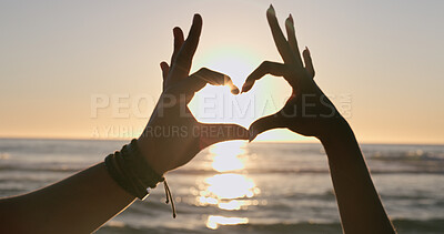 Buy stock photo Love, hands and heart on beach with sunset, water background and horizon for vacation, travel or adventure. People, man and woman by ocean or sea with emoji for romance, care and relationship on trip