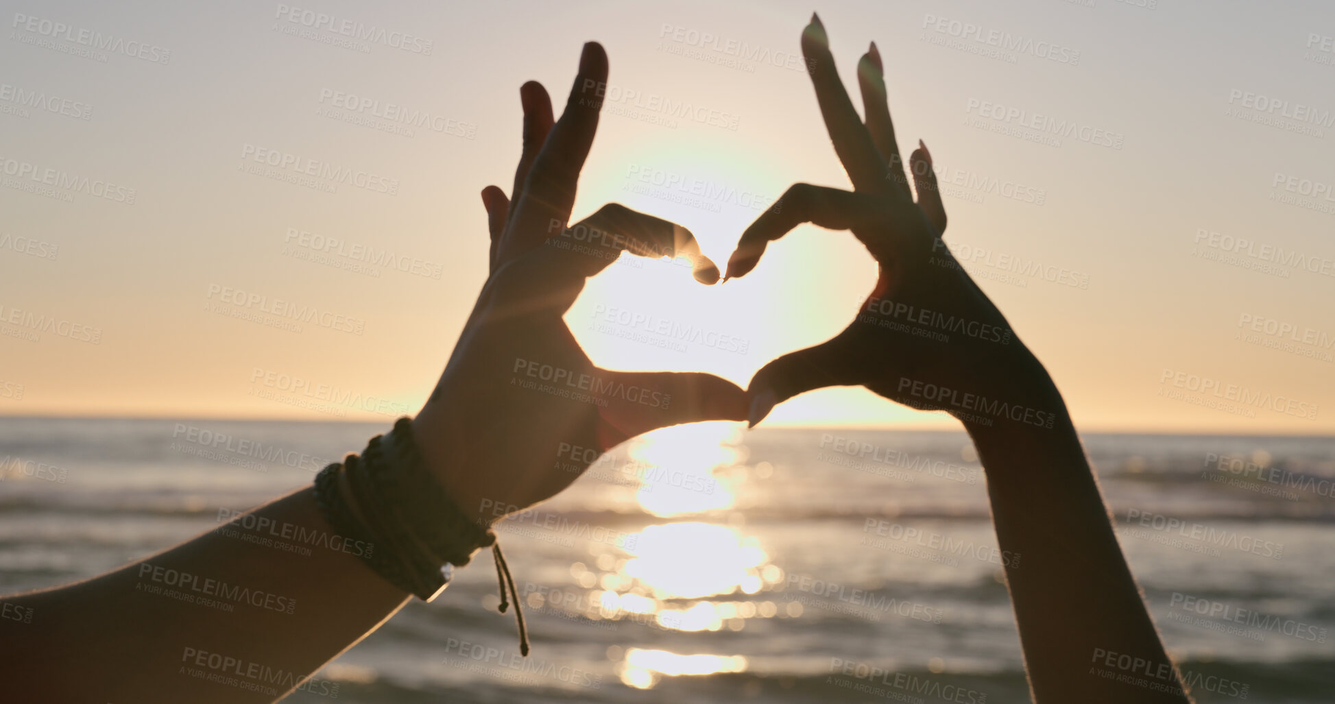 Buy stock photo Love, hands and heart on beach with sunset, water background and horizon for vacation, travel or adventure. People, man and woman by ocean or sea with emoji for romance, care and relationship on trip