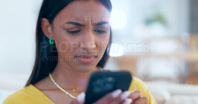 Buy stock photo Confused, doubt and woman networking on a phone on sofa in the living room reading bad news. Upset, mad and young Indian female person scroll on social media or the internet with cellphone at home.