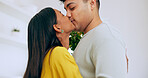 Love, hug and a couple kissing closeup in their home for romance while bonding together on their anniversary. Face, happy or relationship with a man and woman embracing for care on valentines day