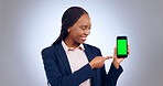 Business, woman and pointing to green screen of phone for advertising space, offer and mockup newsletter in studio. Happy african worker show mobile announcement, promotion or deal on grey background