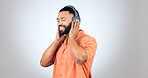 Man, listening and headphones with music in studio, background or mockup with audio streaming. Radio, podcast and calm person relax with hip hop or download sound online to hear with technology