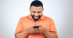 Man in studio with phone, smile and typing with connection for networking, online chat or communication. Good news, notification and happy person writing message, email or post on white background.