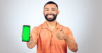 Portrait, man and thumbs up for phone with green screen, space and agreement in studio on white background. Happy model, smartphone and yes emoji for newsletter, promotion and advertising information