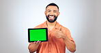 Portrait, man and thumbs up for tablet with green screen, space or agreement of deal in studio on white background. Happy model, digital marketing and like emoji for newsletter, promotion and support