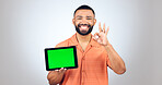 Portrait, man and ok for tablet with green screen, space or advertising agreement in studio on white background. Happy model, digital marketing and yes emoji for promotion, sign up deal or newsletter