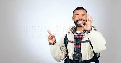 Buy stock photo Hiking portrait, pointing and happy man okay sign for studio promotion, discount deal offer or travel vacation agreement. Ok emoji icon, mockup space and studio hiker backpacking on white background