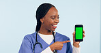 Green screen, doctor and woman with phone pointing for telehealth, wellness app and medical news. Healthcare, mockup and person on smartphone for clinic website, online promo and contact in studio