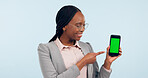 Black woman, pointing at smartphone and green screen, advertising mockup with tracking marker in studio. Information, marketing for app or website, communication and ads for tech on blue background