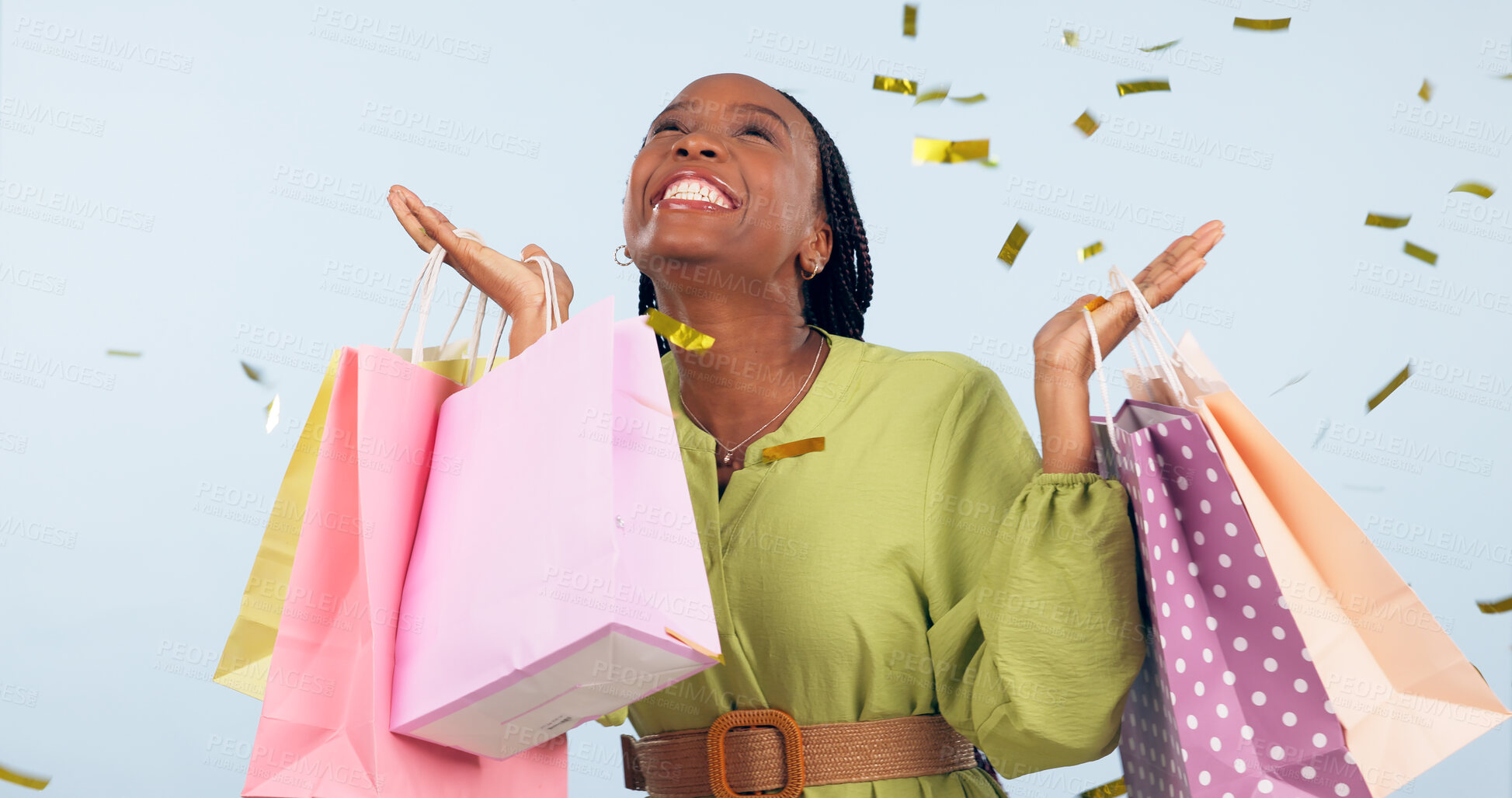 Buy stock photo Confetti, shopping and happy woman in studio with motivation from gift purchase. Giveaway, celebration and excited female customer with blue background and store bags for birthday or holiday sale