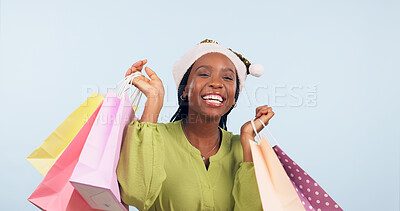 Buy stock photo Christmas, shopping and happy woman in studio with motivation from gift purchase. Giveaway, celebration and excited female customer with blue background and store bags for birthday or holiday sale