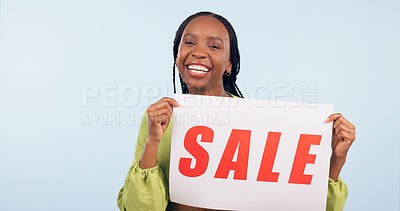 Buy stock photo Happy black woman, sale and sign with poster for discount promotion on a studio blue background. Portrait of African female person showing banner for shopping deal, store promo or advertising