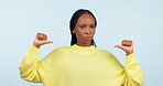 Portrait, attitude and a pointing black woman with confidence in studio on a gray background. Face, frown and expression with a young person looking serious about her fashion or style choice