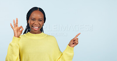 Buy stock photo Pointing, portrait and black woman with opportunity, ok sign and announcement on a blue studio background. African person, model and girl with hand gesture, mockup space and agreement with feedback