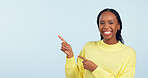 Pointing, portrait and black woman with opportunity, feedback and announcement on blue studio background. African person, model or girl with hand gesture, mockup space and decision with news or smile