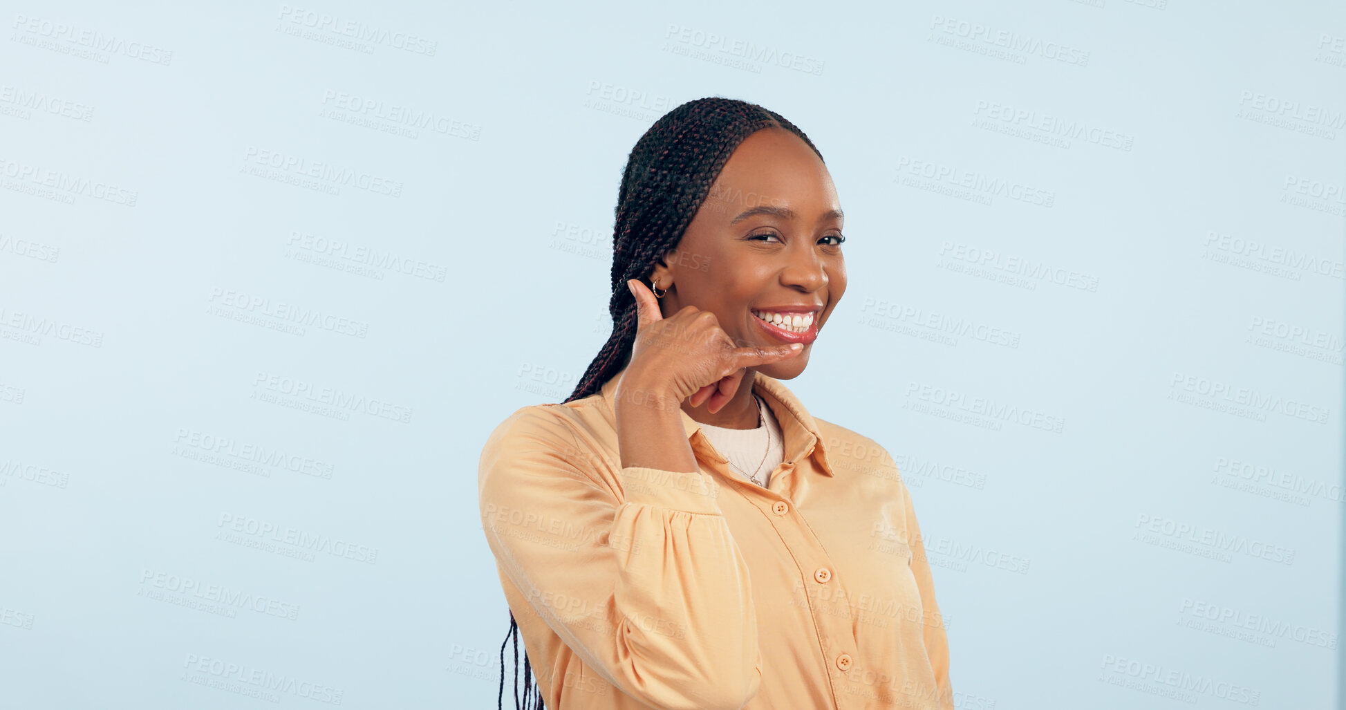 Buy stock photo Portrait, woman and smile for call me, hand sign and communication in studio on blue background. Happy african model show gesture of mobile chat, conversation or contact for networking, talk or emoji