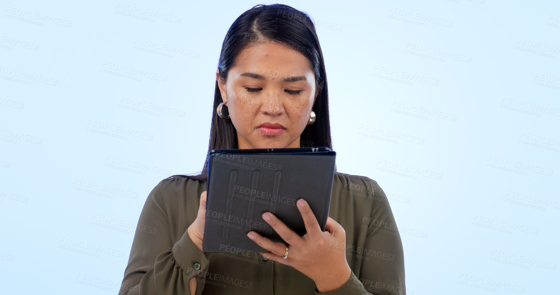 Buy stock photo Business, woman and tablet in studio for research, networking and planning with serious expression on blue background. Person, touchscreen or technology for scrolling on website or corporate search